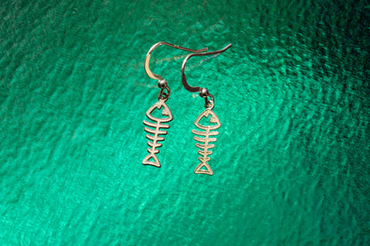 a pair of sterling silver earrings shaped as fish skeletons