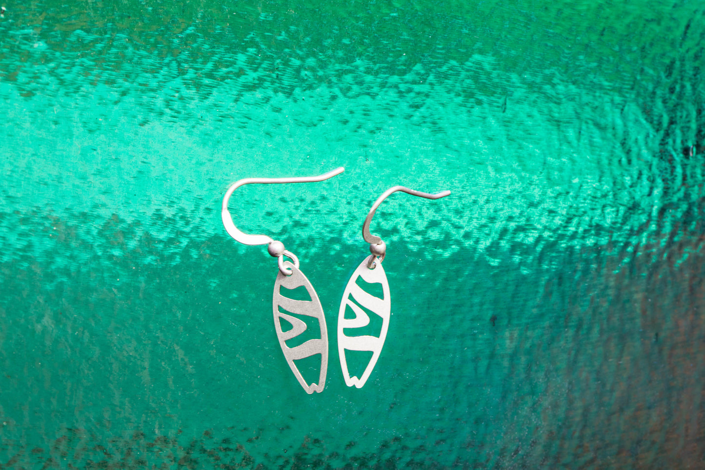 Matt sterling silver earrings on a wave background