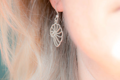 A nautilus shell inspired sterling silver earring worn by model