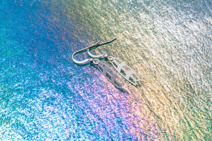a pair of surfboard styled earrings on a purple and gold background